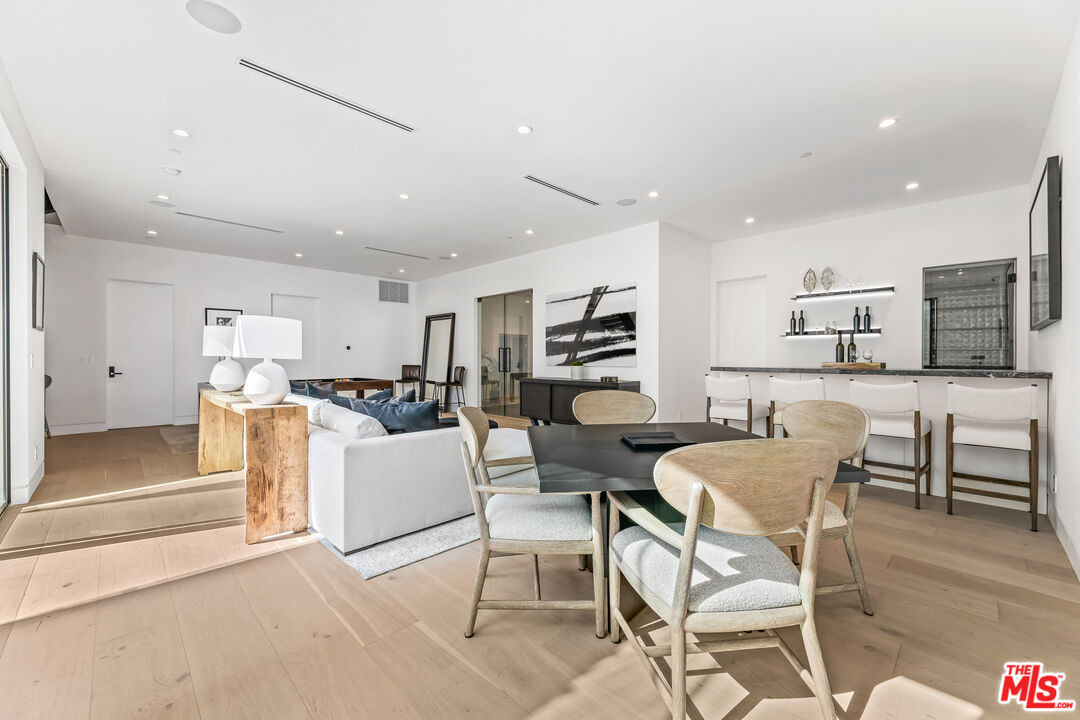 12119 Travis Street Los Angeles, CA 90049 - Photo 21 of 26 a living room with stainless steel appliances kitchen island granite countertop furniture and a dining table with kitchen view