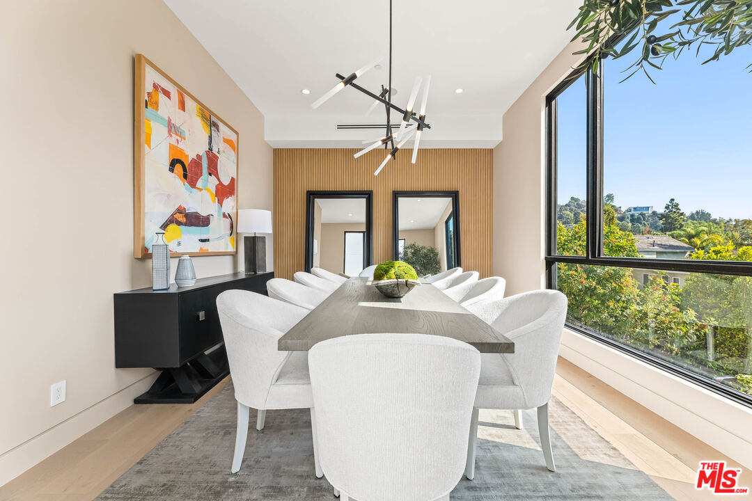 12119 Travis Street Los Angeles, CA 90049 - Photo 5 of 26 a view of a dining room with furniture large windows and wooden floor