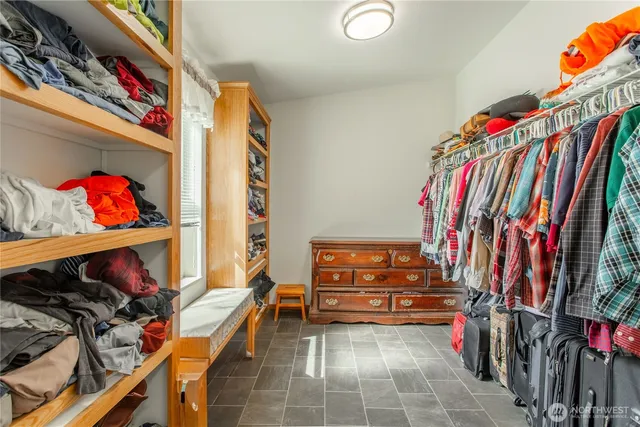 a view of walk in closet with clothes and shoes