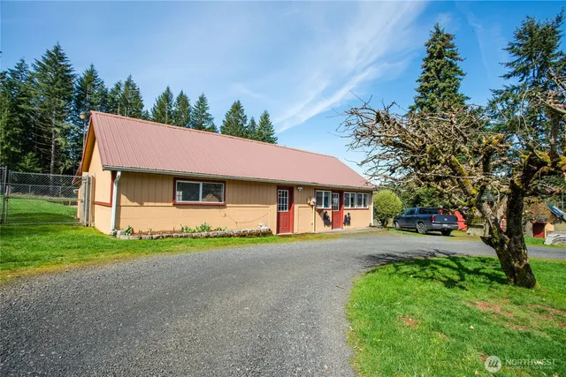 a front view of a house with a garden and trees