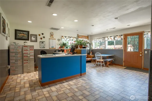 a kitchen with stainless steel appliances kitchen island granite countertop a refrigerator and a sink