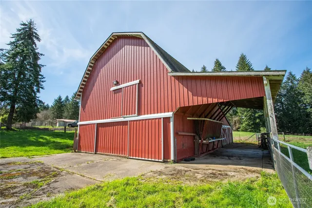 a view of a backyard with a barn and a cactus plant