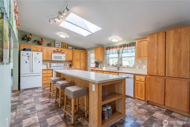 a kitchen with stainless steel appliances granite countertop a refrigerator a sink dishwasher and a stove with wooden cabinets