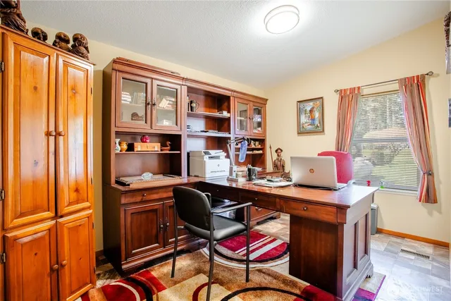 a view of a workspace with furniture and a window