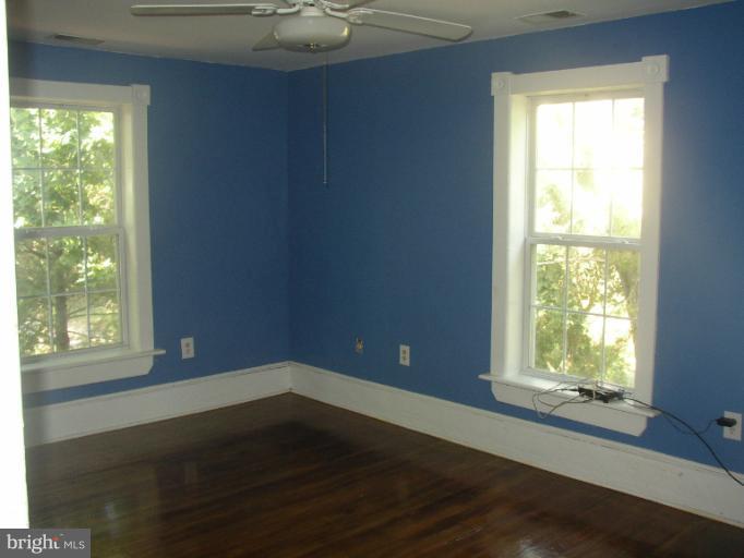 933 Guard Hill Road Middletown, VA 22645 - Photo 21 of 26 a view of an empty room with wooden floor and a window