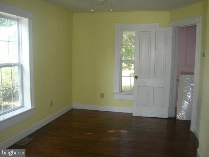 933 Guard Hill Road Middletown, VA 22645 - Photo 24 of 26 a view of an empty room with wooden floor and a window