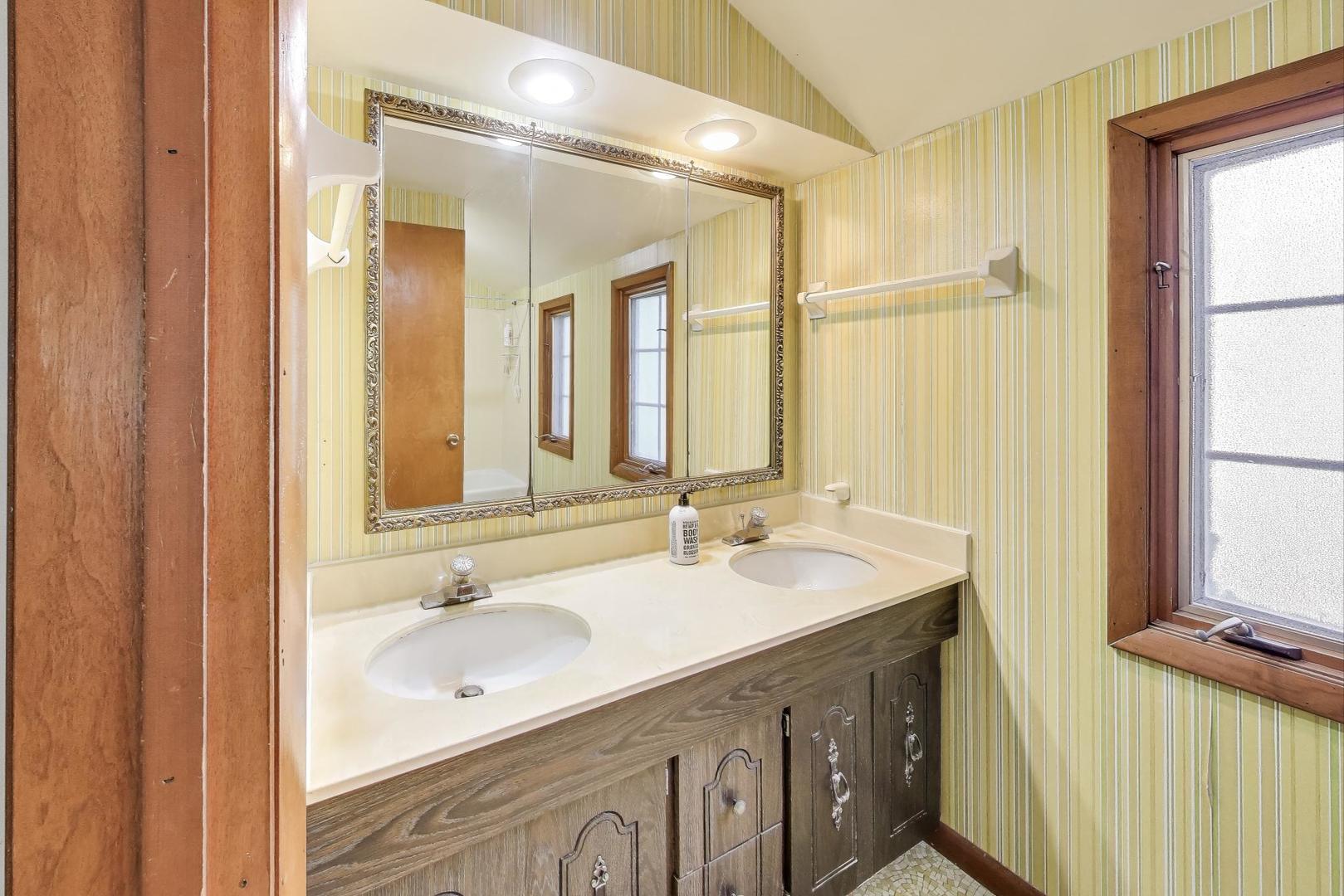 2113 Forestview Road Evanston, IL 60201 - Photo 13 of 18 a bathroom with a double vanity sink and a mirror