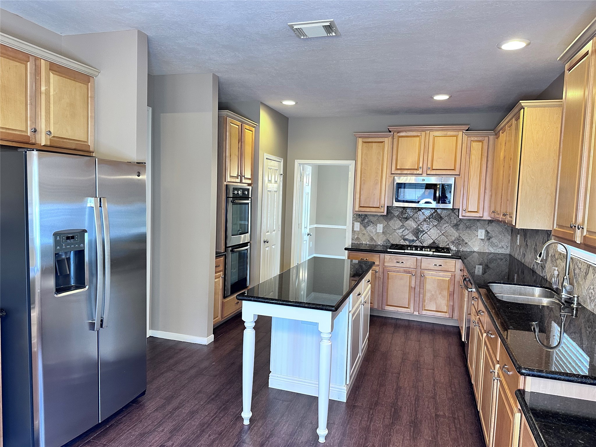 3411 Bay Breeze Drive Seabrook, TX 77586 - Photo 13 of 46 a kitchen with stainless steel appliances granite countertop a refrigerator a sink dishwasher a oven and a dining table with wooden floor