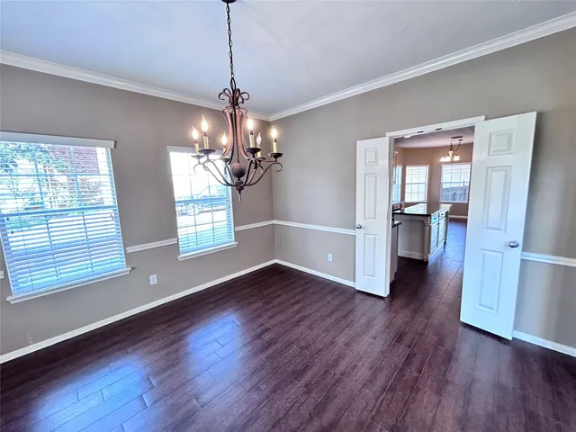 a kitchen with stainless steel appliances granite countertop a refrigerator a sink dishwasher a oven and a dining table with wooden floor