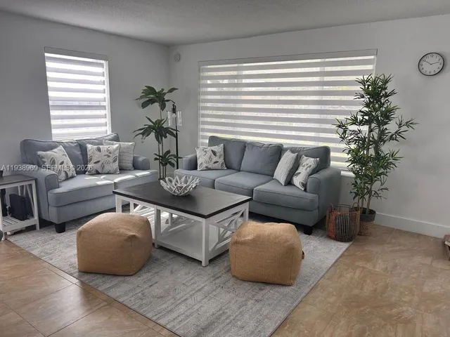 a living room with furniture and a potted plant