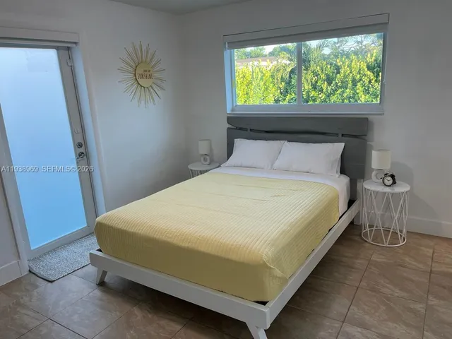 a bed sitting in a bedroom next to a window