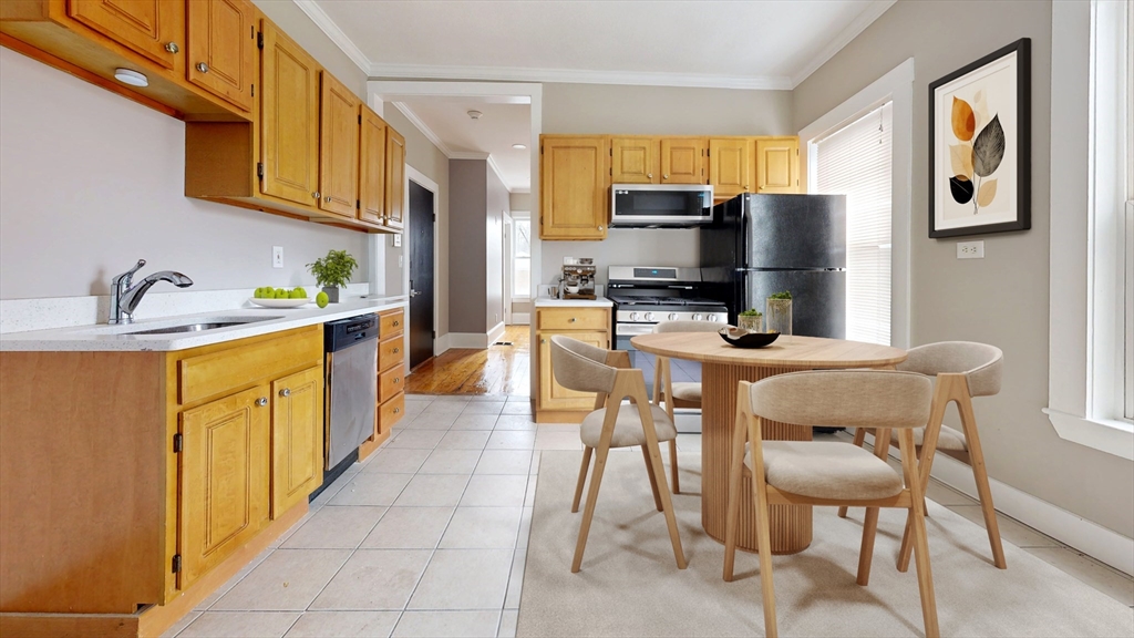 46-48 Fuller Street, Unit 48 1 Boston, MA 02124 - Photo 1 of 8 a kitchen with stainless steel appliances kitchen island granite countertop a refrigerator a stove a microwave oven a sink with island and chairs