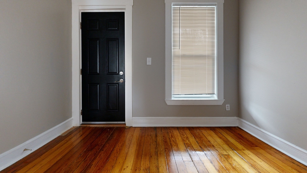 46-48 Fuller Street, Unit 48 1 Boston, MA 02124 - Photo 4 of 8 an empty room with wooden floor and windows