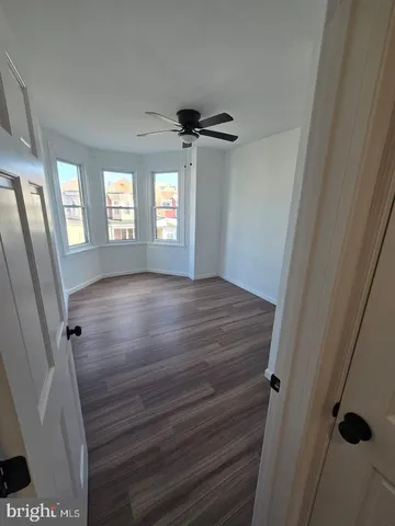 a view of empty room with window and hardwood floor