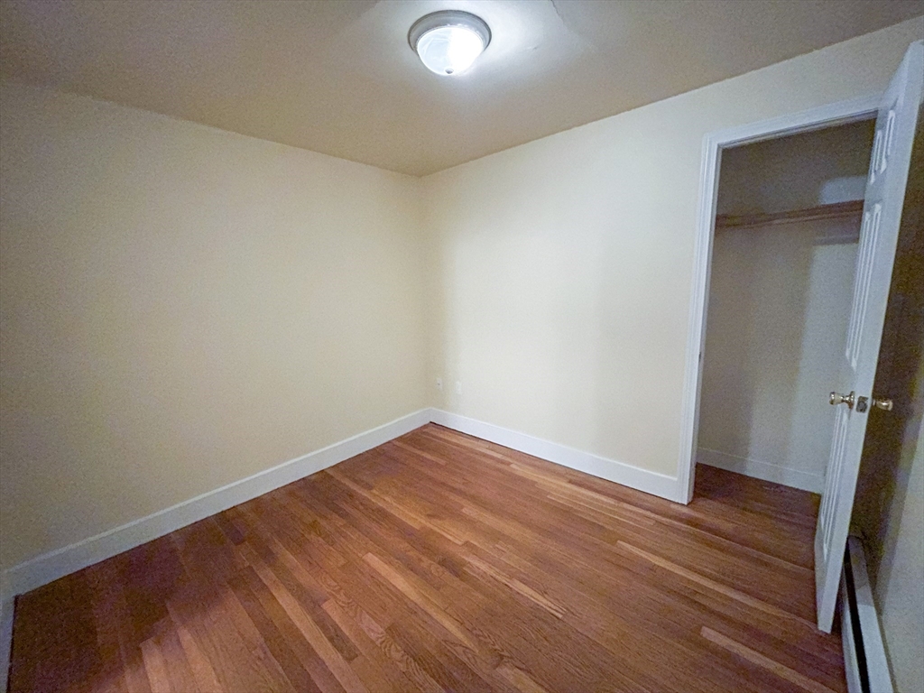 1911 River Street, Unit 2 Boston, MA 02136 - Photo 11 of 16 an empty room with wooden floor and closet