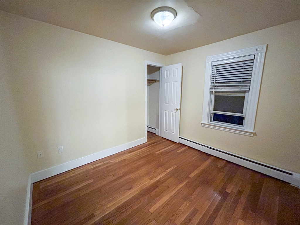 1911 River Street, Unit 2 Boston, MA 02136 - Photo 14 of 16 a view of an empty room with wooden floor and a window