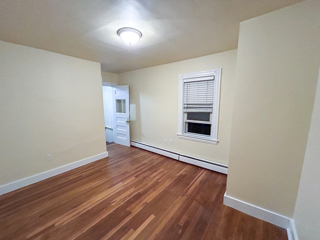 1911 River Street, Unit 2 Boston, MA 02136 - Photo 5 of 16 a view of an empty room with wooden floor and a window