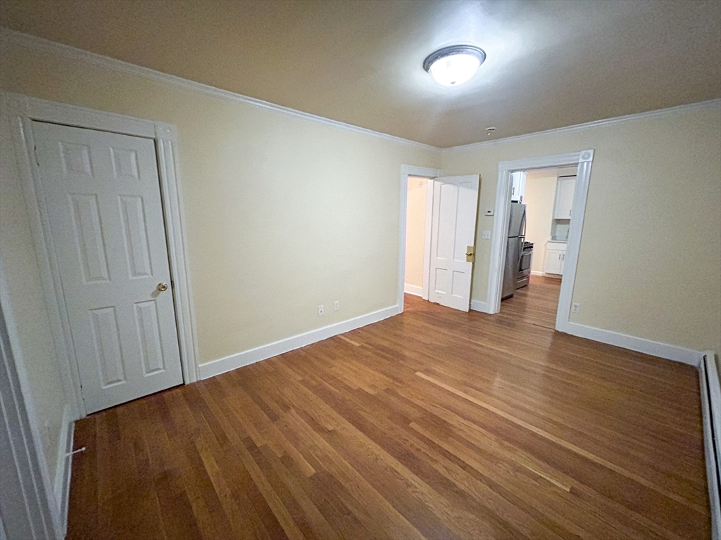 1911 River Street, Unit 2 Boston, MA 02136 - Photo 10 of 16 wooden floor in an empty room with a window
