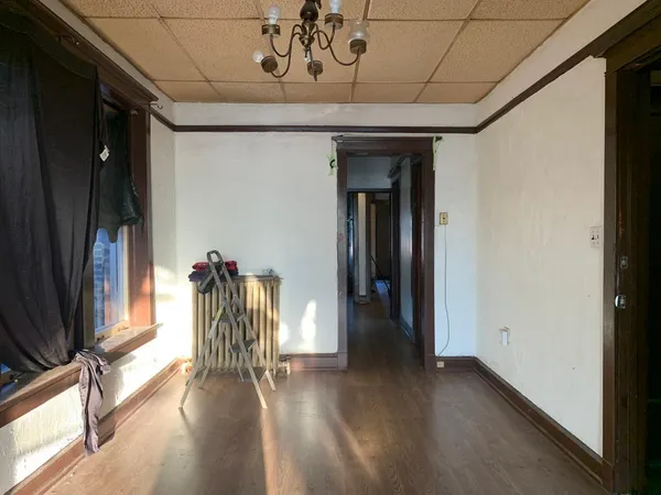 a hallway with wooden floor and a chandelier