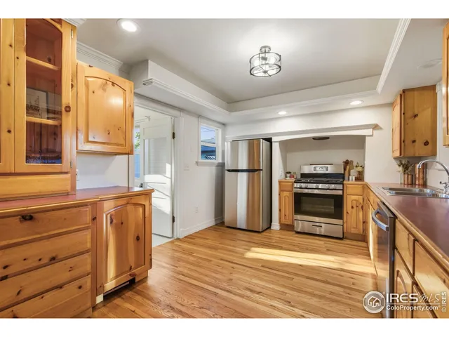 a kitchen with granite countertop a refrigerator and a stove top oven