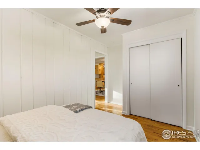 a bedroom with a bed and a chandelier fan