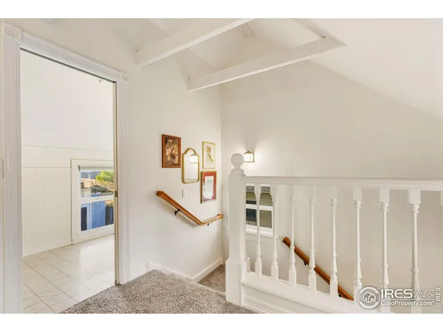 a view of a hallway with wooden floor and stairs
