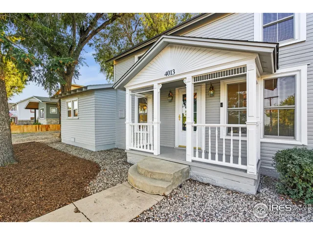 a view of a house with a small yard and wooden fence