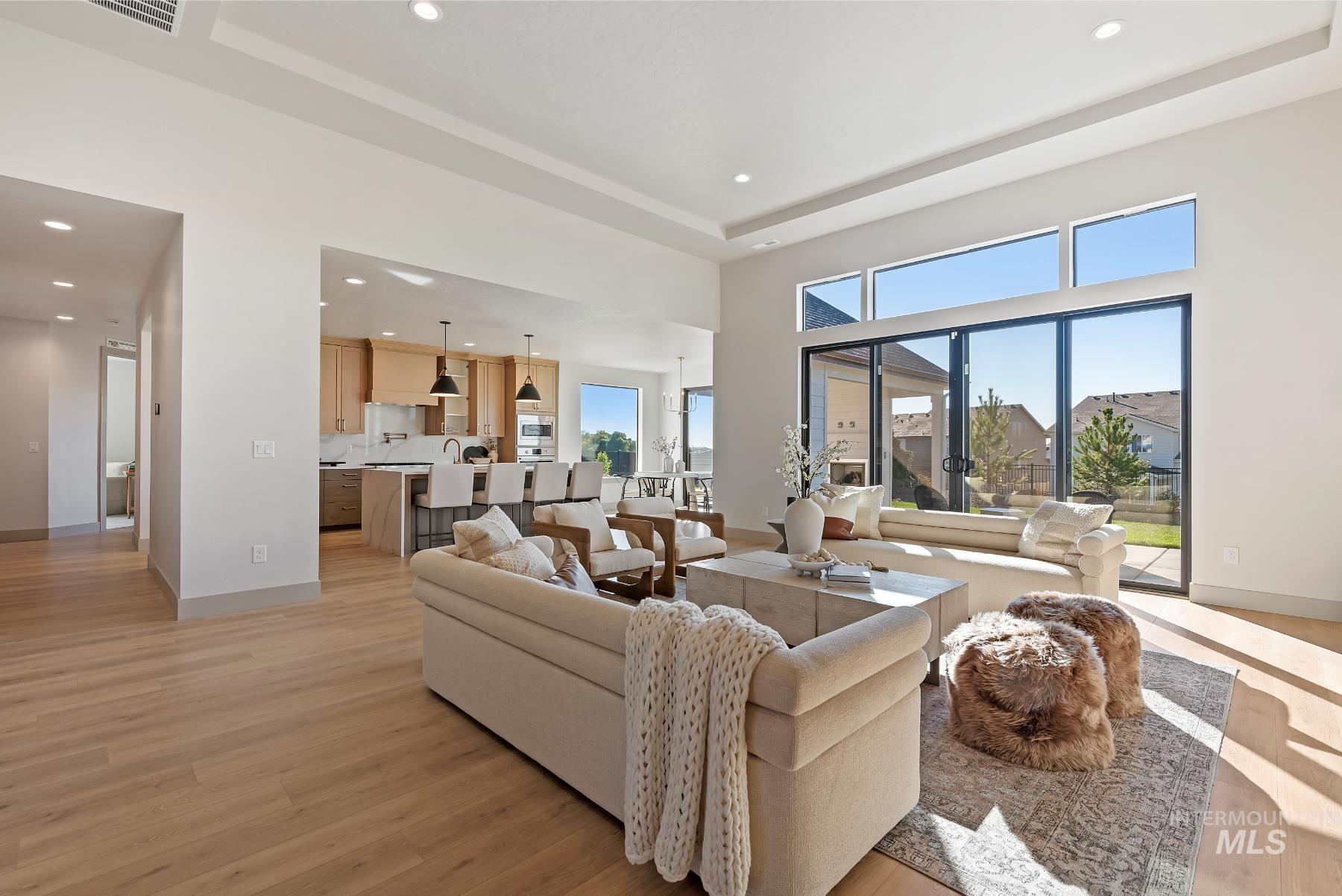 8530 West Graye Street, Unit SHASTA Meridian, ID 83646 - Photo 9 of 28 Living room with light wood-style flooring, a raised ceiling, recessed lighting, and a towering ceiling