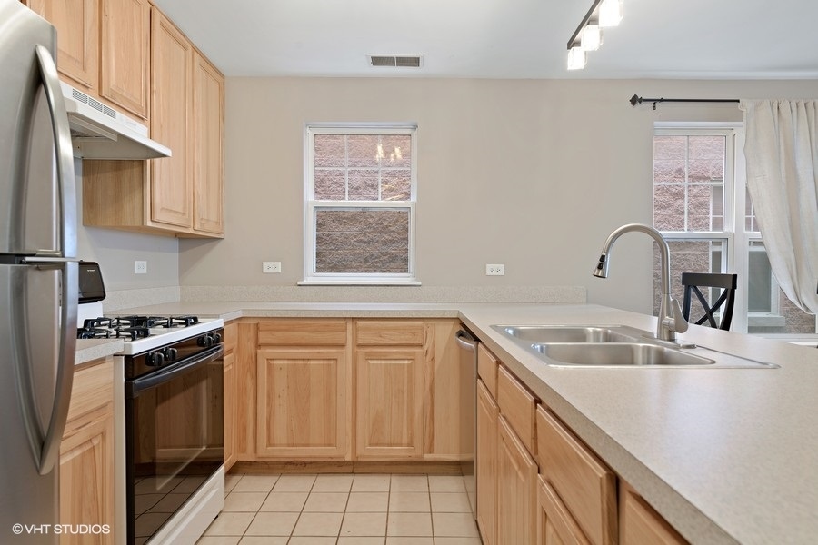 649 West Division Street, Unit B Chicago, IL 60610 - Photo 4 of 15 a kitchen with granite countertop a sink stove and refrigerator