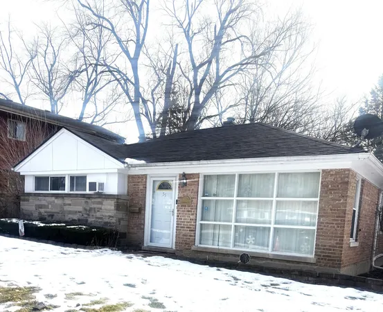 a front view of a house with a yard covered in snow