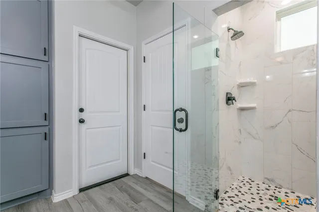 a bathroom with a shower and a glass door
