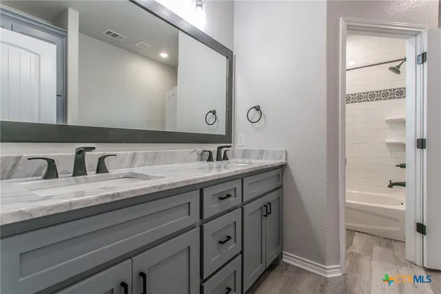 a bathroom with a granite countertop sink and a mirror