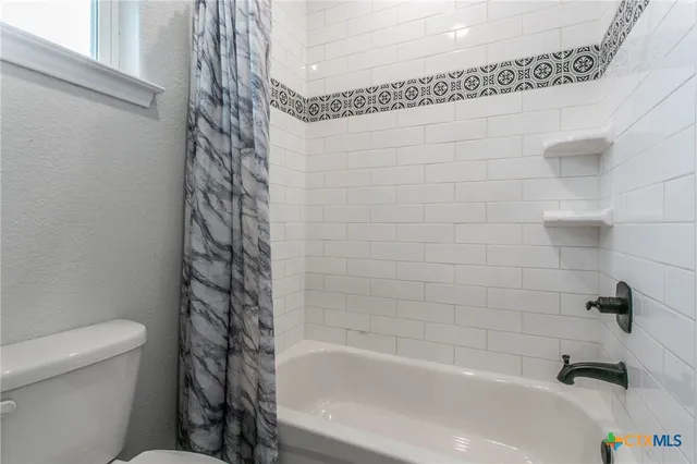 a bathroom with a bathtub and a toilet