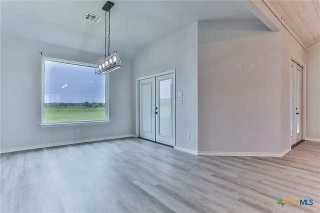 a view of a room with wooden floor chandelier and window