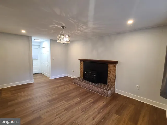 wooden floor fireplace and windows in an empty room
