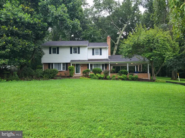 a front view of a house with a yard and trees