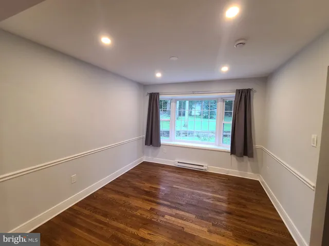 a view of a hallway with wooden floor and a window