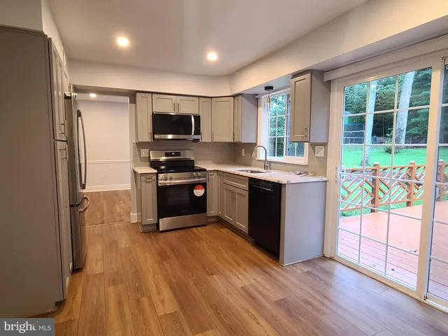 a view of kitchen with refrigerator stove microwave and cabinets
