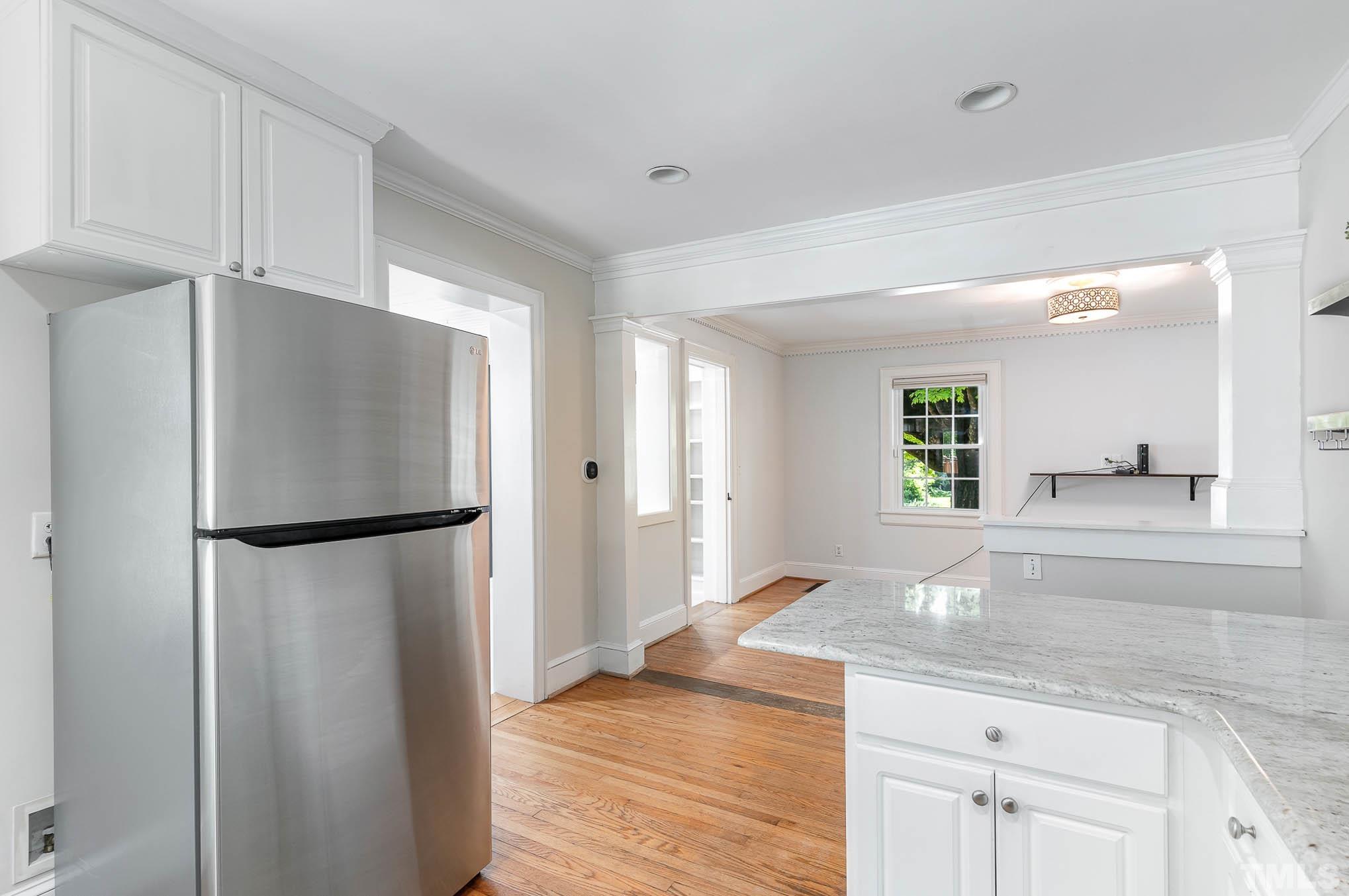 723 East Whitaker Mill Road Raleigh, NC 27608 - Photo 17 of 38 a kitchen with a refrigerator a sink and a large mirror
