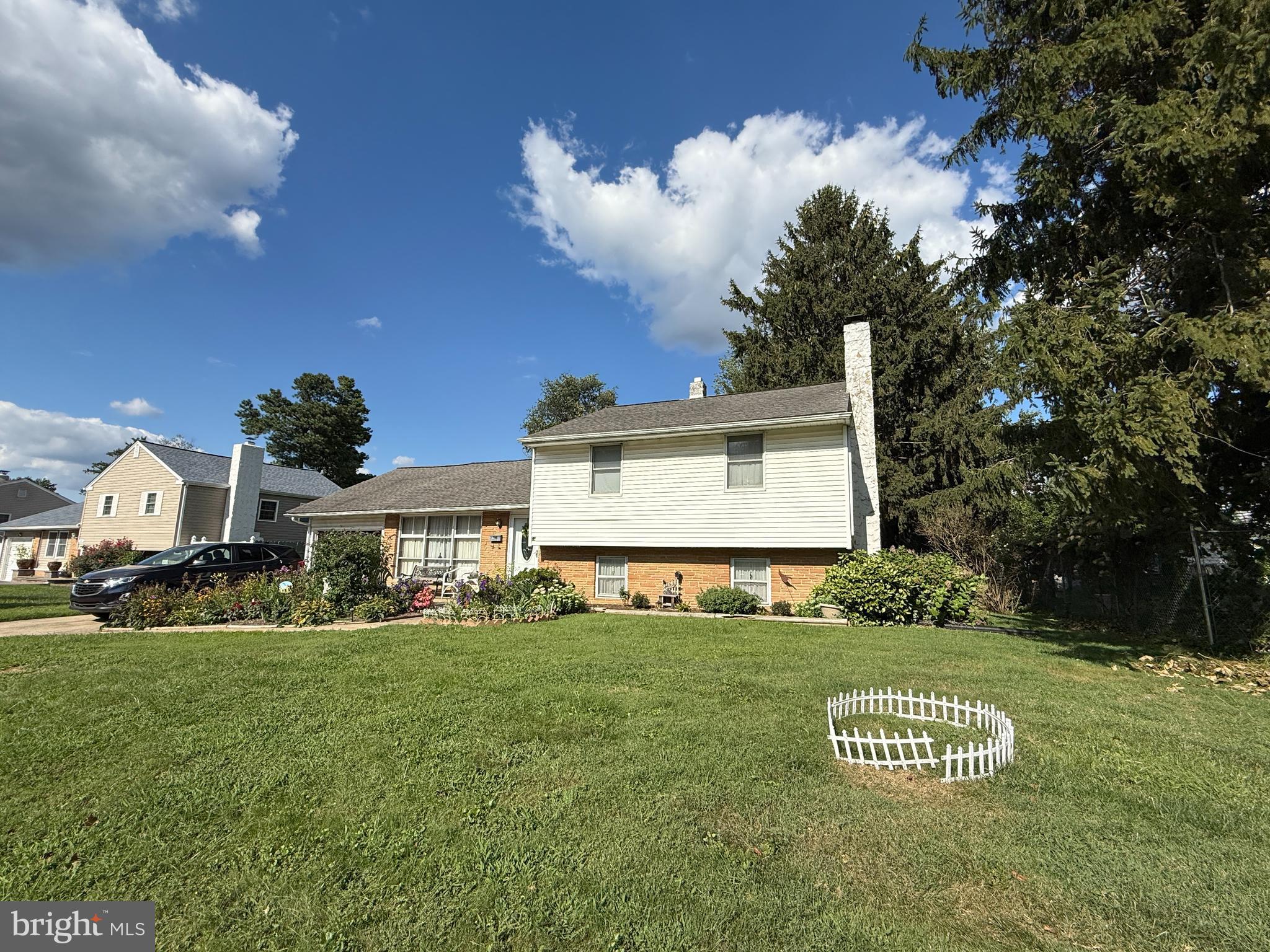 a view of a white house with a big yard and potted plants
