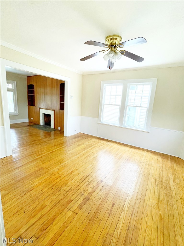 3345 Sylvanhurst Road Cleveland Heights, OH 44112 - Photo 7 of 16 Unfurnished living room with light hardwood / wood-style flooring, ceiling fan, and ornamental molding