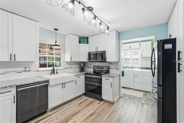a kitchen with a sink stove cabinets and refrigerator