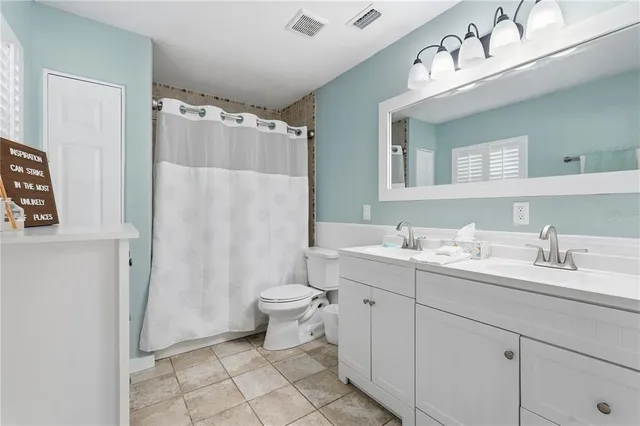 a bathroom with a sink vanity mirror and toilet