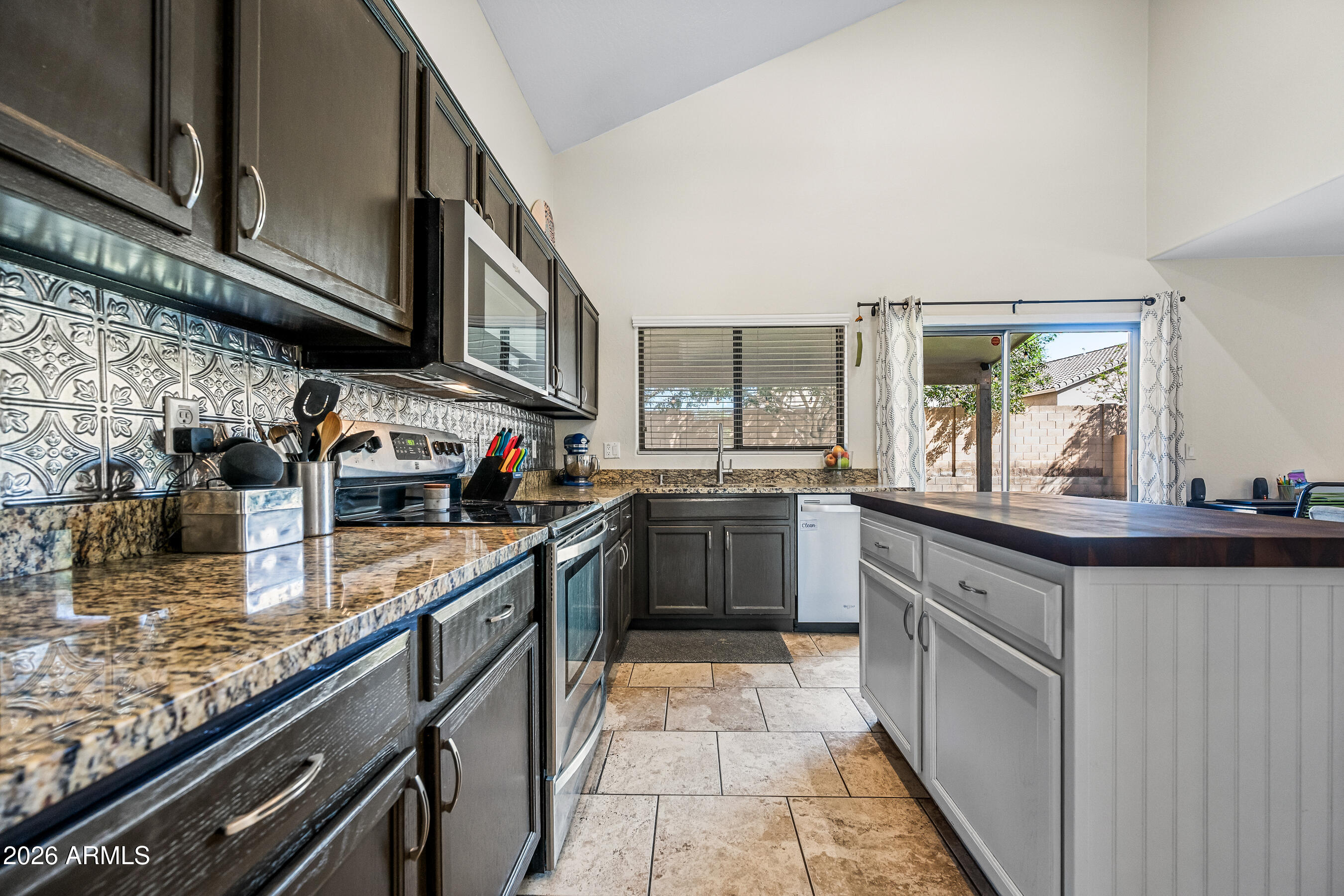 12734 West Cheery Lynn Road Avondale, AZ 85392 - Photo 21 of 54 a kitchen with stainless steel appliances granite countertop a stove a sink and a microwave