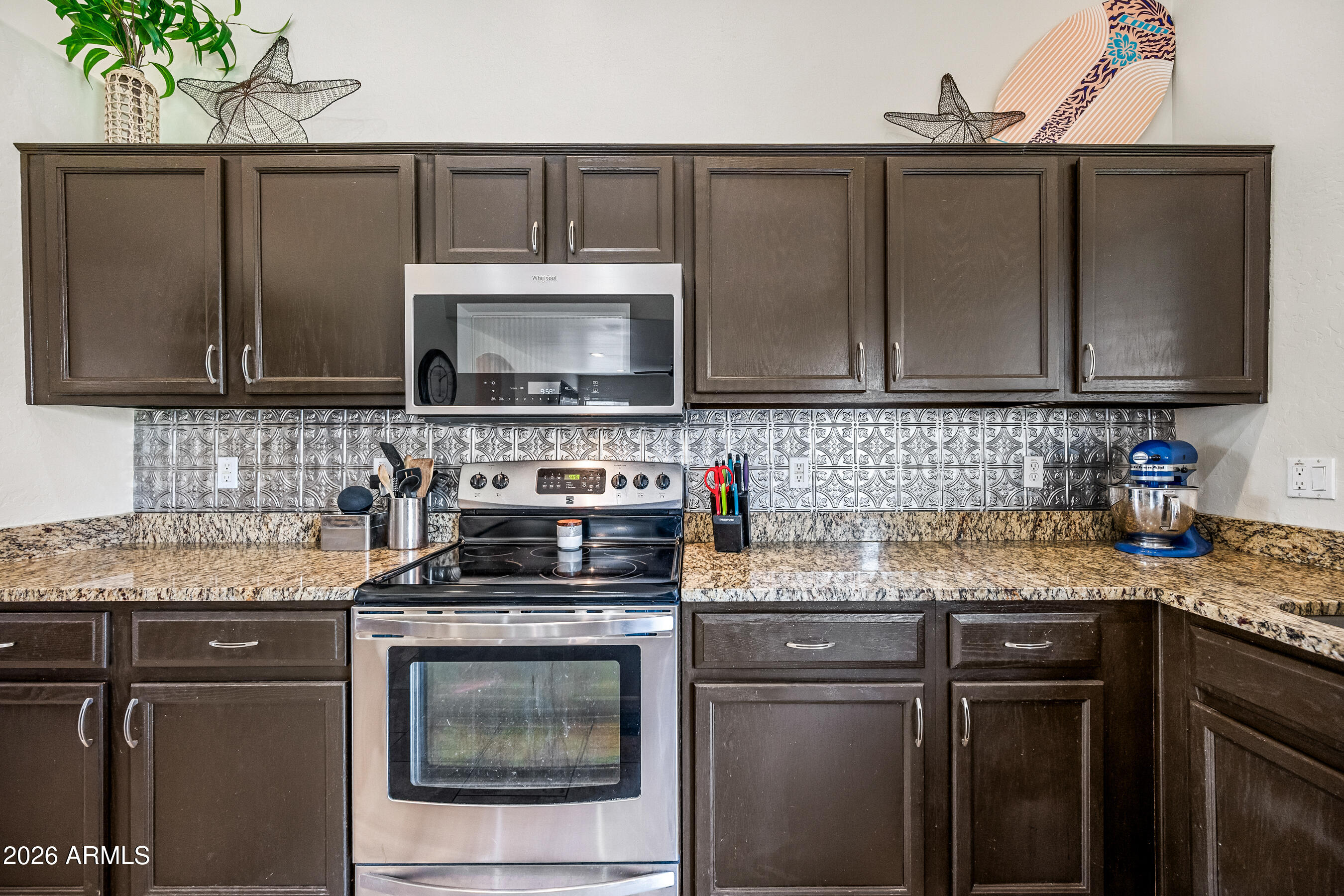 12734 West Cheery Lynn Road Avondale, AZ 85392 - Photo 25 of 54 a kitchen with granite countertop a sink stove and microwave