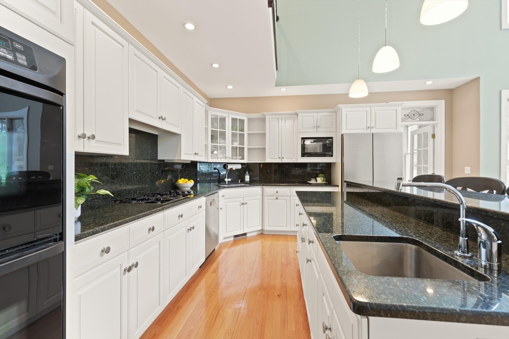 33 Bulkley Road Sudbury, MA 01776 - Photo 14 of 42 a kitchen with stainless steel appliances granite countertop a sink a stove and cabinets