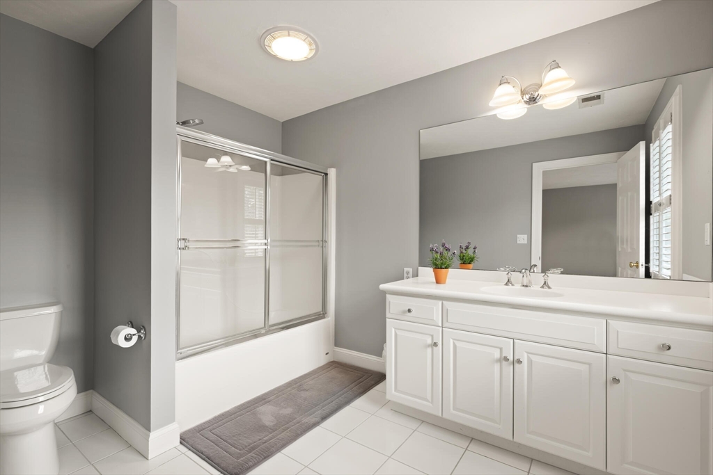 33 Bulkley Road Sudbury, MA 01776 - Photo 28 of 42 a bathroom with a sink a toilet a large mirror and vanity