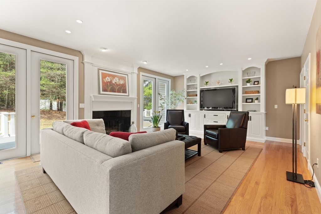 33 Bulkley Road Sudbury, MA 01776 - Photo 9 of 42 a living room with furniture a flat screen tv and a fireplace