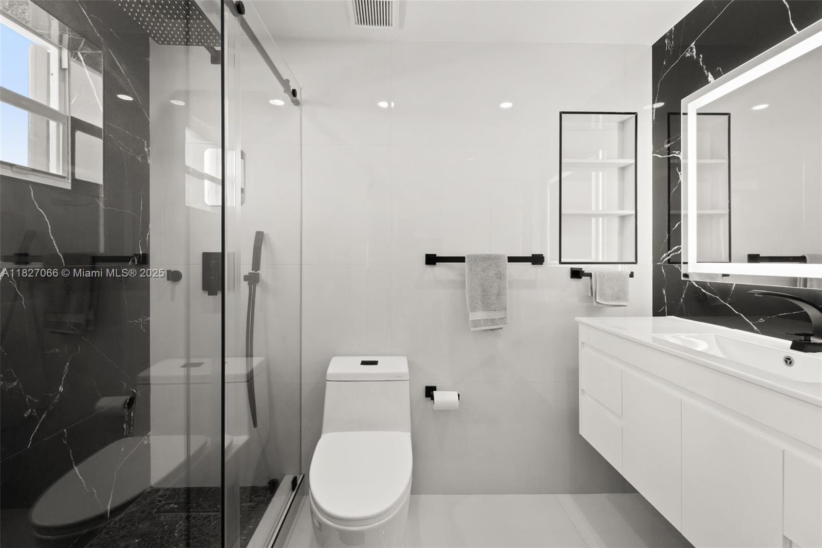 1050 93rd Street, Unit 7H Bay Harbor Islands, FL 33154 - Photo 12 of 18 a bathroom with a toilet a sink and shower