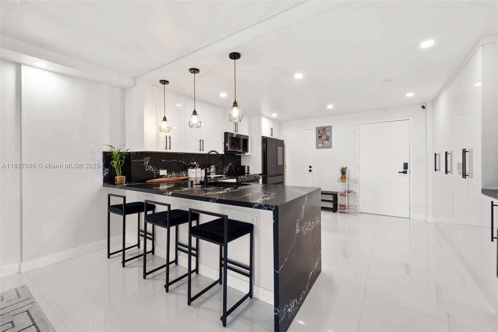 1050 93rd Street, Unit 7H Bay Harbor Islands, FL 33154 - Photo 2 of 18 a kitchen with stainless steel appliances kitchen island granite countertop a stove a sink a refrigerator and white cabinets